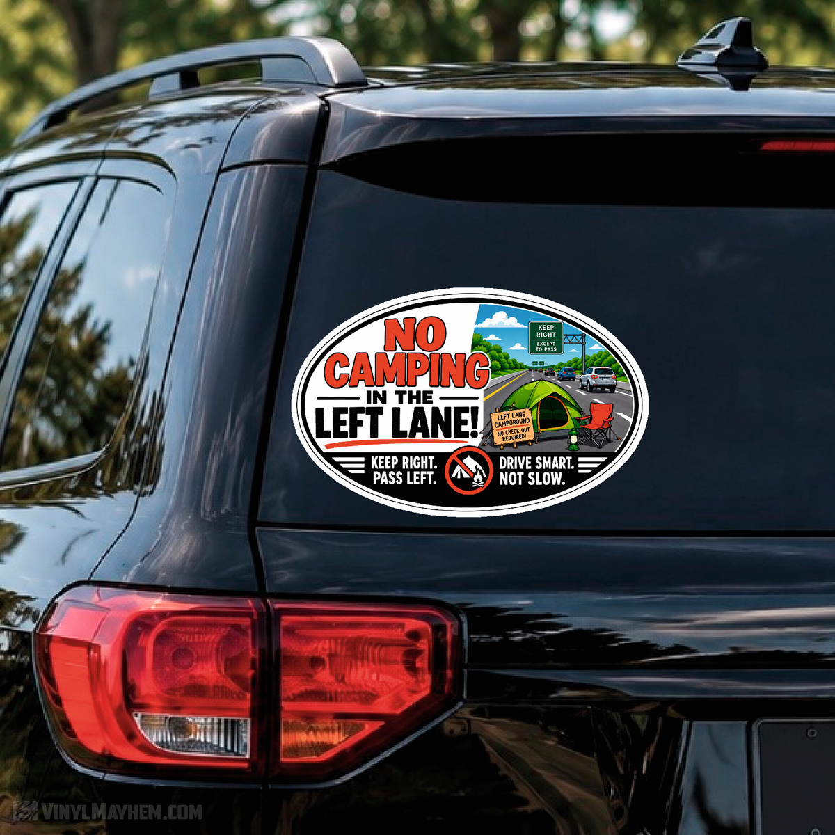 An oval vinyl decal sticker applied to the rear window of a black SUV. The sticker features a humorous traffic sign illustration with the text 'NO CAMPING IN THE LEFT LANE!' and warning labels.