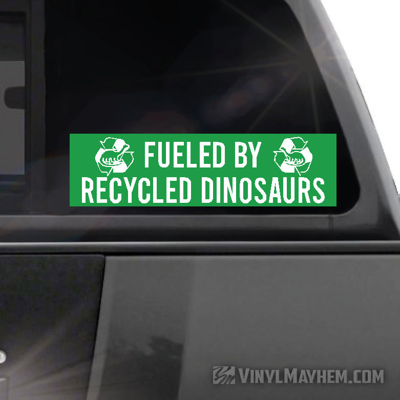 Green bumper sticker with 'Fueled by Recycled Dinosaurs' text on a car window, brand 'Vinyl Mayhem' visible.
