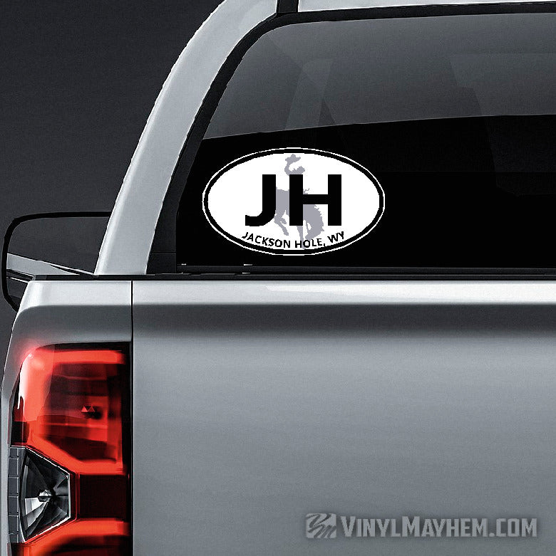 Car decal with &#39;JH&#39; and &#39;Jackson Hole, WY&#39; on a vehicle&#39;s rear window.