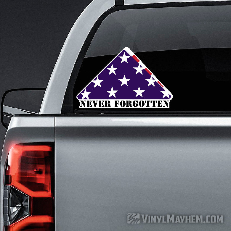 Triangular &#39;Never Forgotten&#39; decal on a car&#39;s rear window with &#39;Vinyl Mayhem&#39; branding.