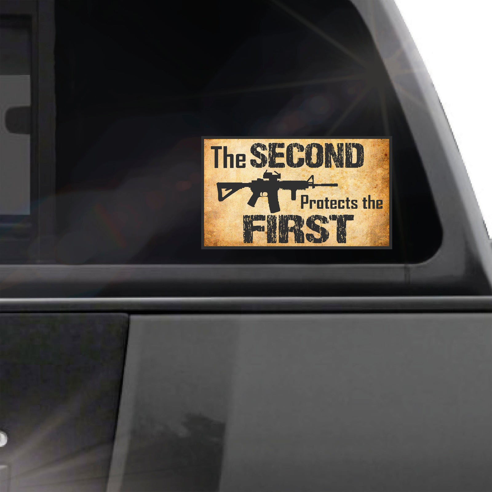 Sticker on a car window with text 'The Second Protects the First' and an AR-15 graphic.